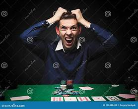 Image of a poker player that is obviously on tilt and has lost control of his emotions, leading to his losing money in the poker game due to his poor decisions.